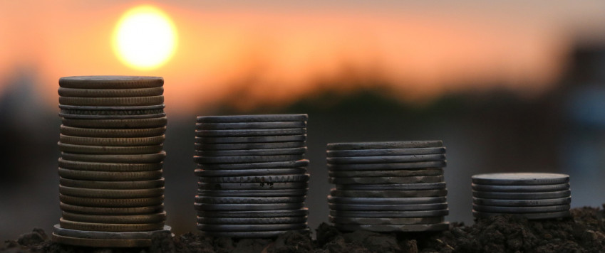 Coins in sunrise, illustrative picture