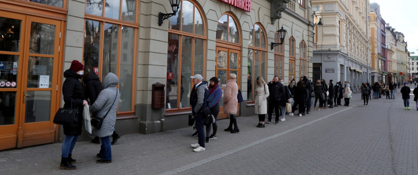 People standing in the queue in the front of shop