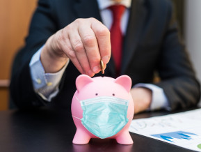 Male putting money in a piggy bank, illustrative picture