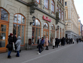 People standing in the queue in the front of shop